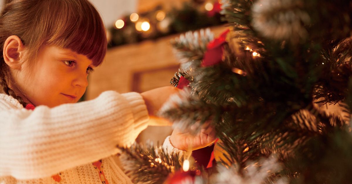Niña montando árbol de Navidad