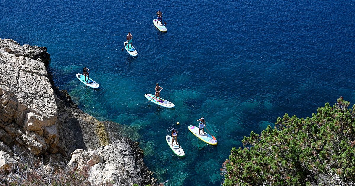 Personas practicando paddle surf en costa de Ibiza