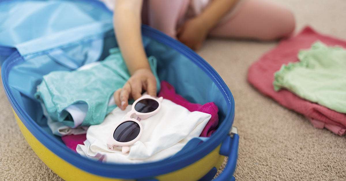 nina haciendo maleta vacaciones familiares