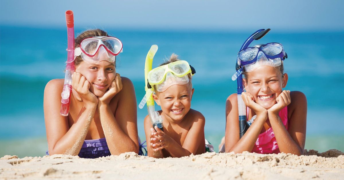 Niños con gafas de buceo en la playa